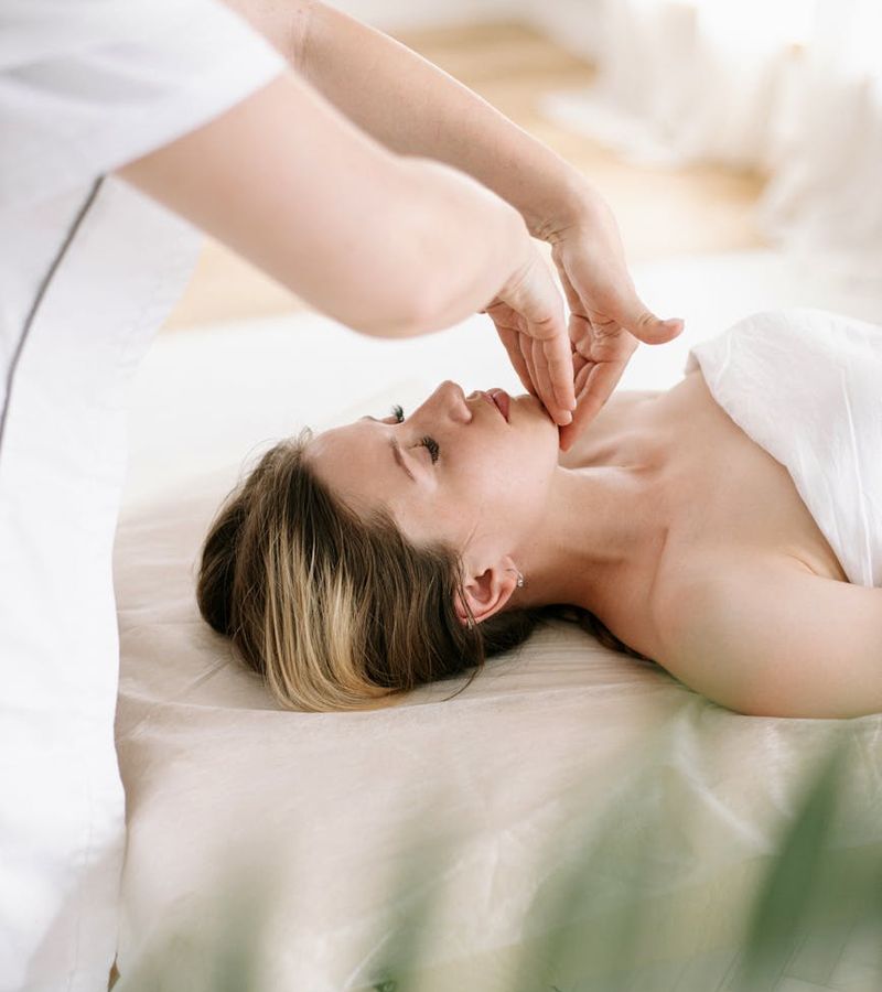 Serene woman with closed eyes practicing relaxation techniques in soft light.